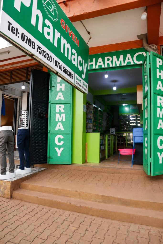 Given Pharmacy Gateway Clive Road West branch storefront in Jinja featuring green signage, contact details, and open folding doors.